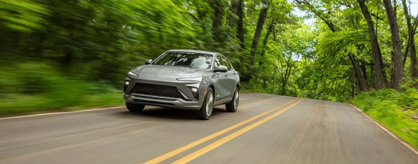 Grey 2025 Buick Envista driving down a road.