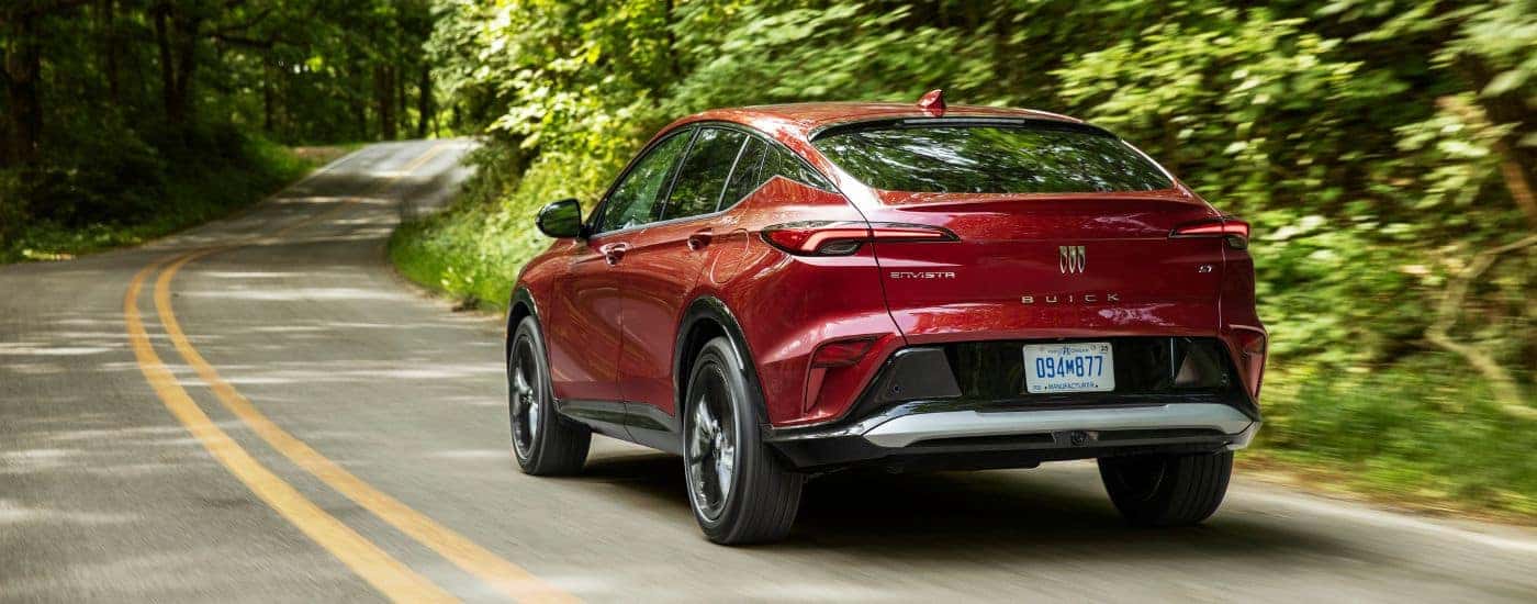 Rear of a red 2025 Buick Envista ST driving down a road.