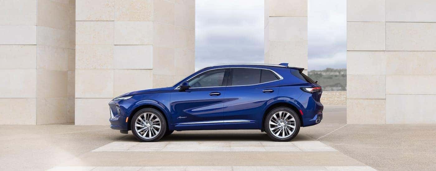 Side of a blue 2026 Buick Envision parked near a building.