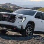 A white 2026 GMC Acadia off-roading.
