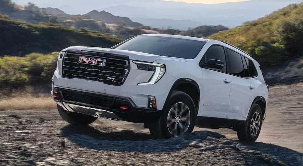 A white 2026 GMC Acadia off-roading.