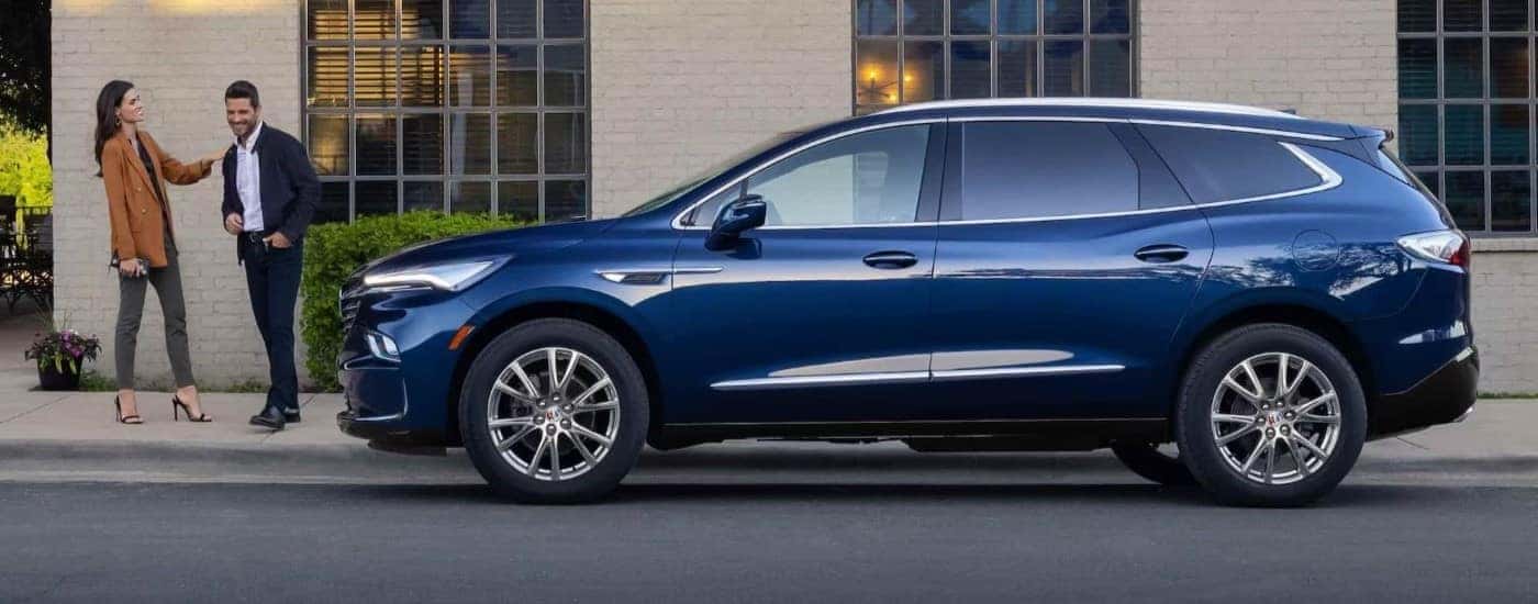 Blue 2024 Buick Enclave parked near a building