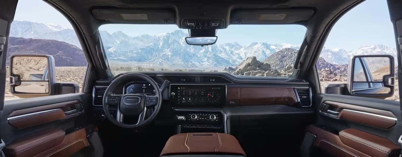 The black and brown interior and dash of a 2024 GMC Sierra 3500 HD is shown.