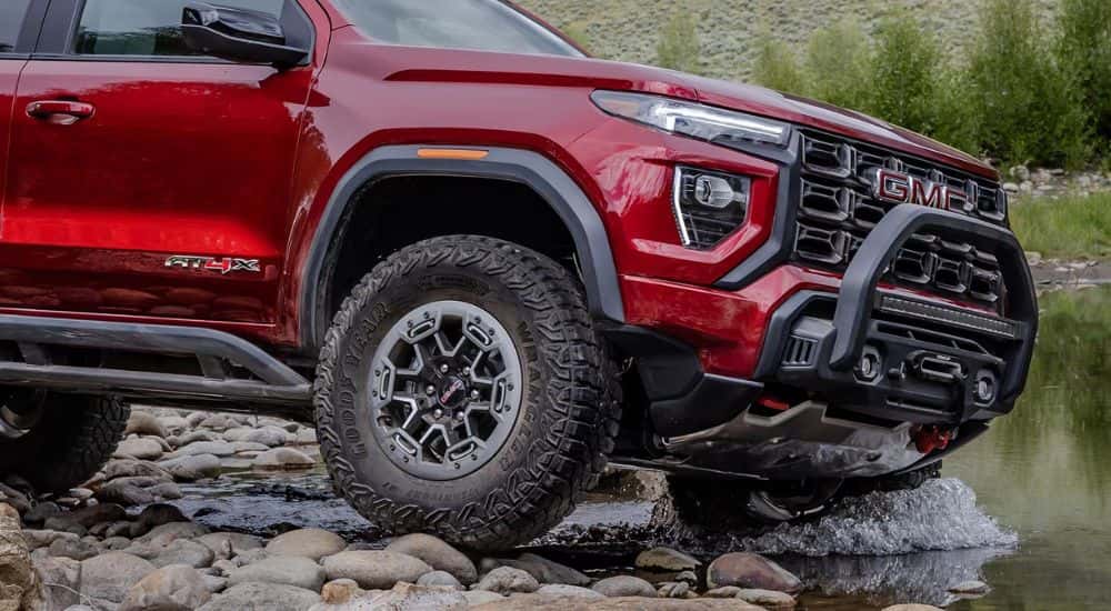 Red 2026 GMC Canyon AT4X off roading into a river