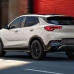 WHite 2026 Buick Encore GX driving down a city street