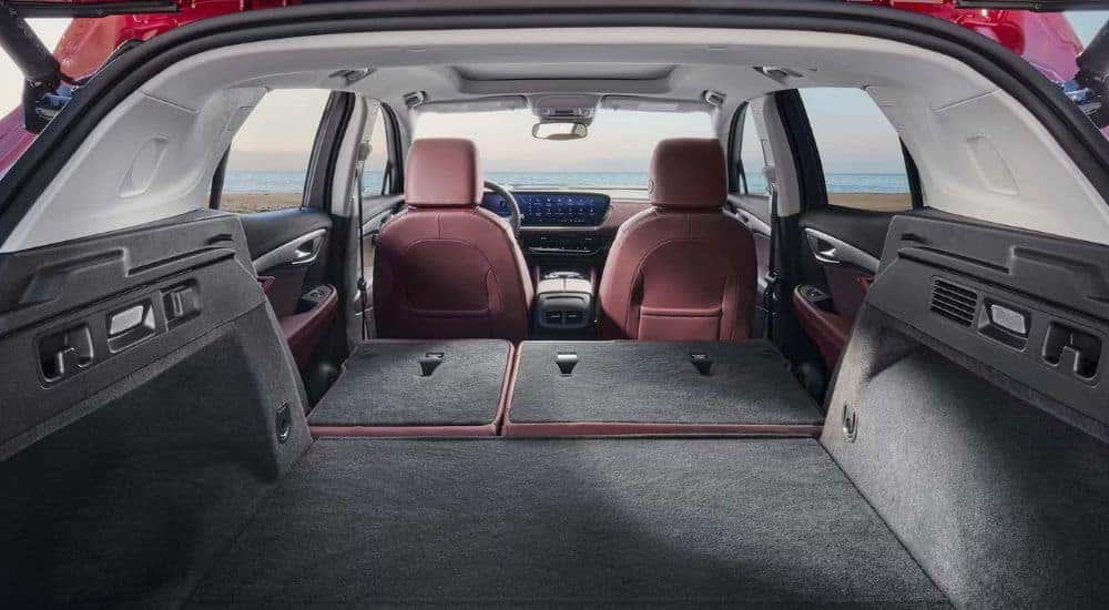 A red 2026 Buick Envision interior shown from the rear with seats down.