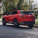 A red 2026 Buick Envision shown parked next to trees.