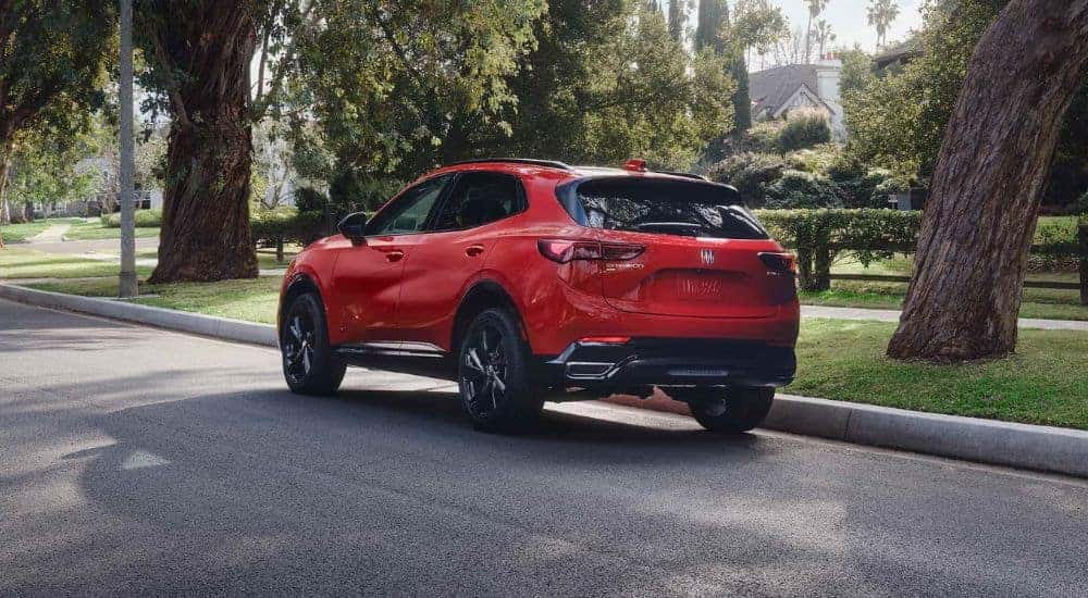 A red 2026 Buick Envision shown parked next to trees.