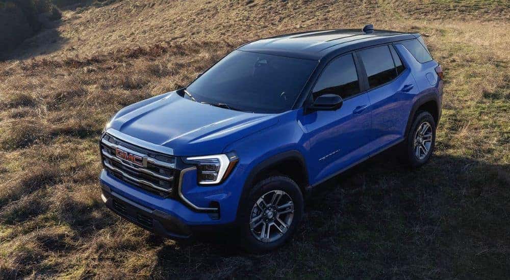 A blue 2026 GMC Terrain parked in a field at an angle.