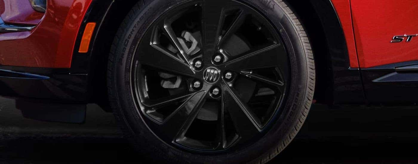 Close-up of a wheel and tire on a red 2026 Buick Envision ST.