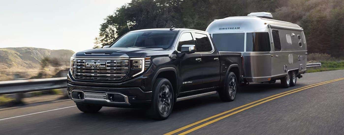 A black 2026 GMC Sierra 1500 Denali towing a trailer.