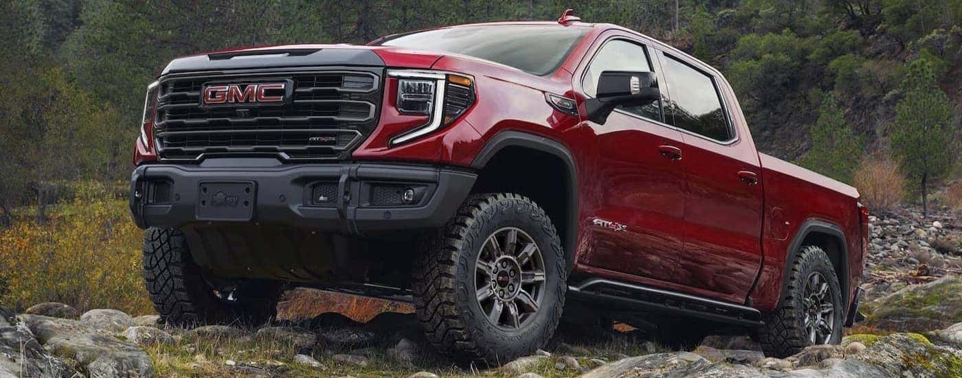 A red 2026 GMC Sierra 1500 AT4X parked offroad.
