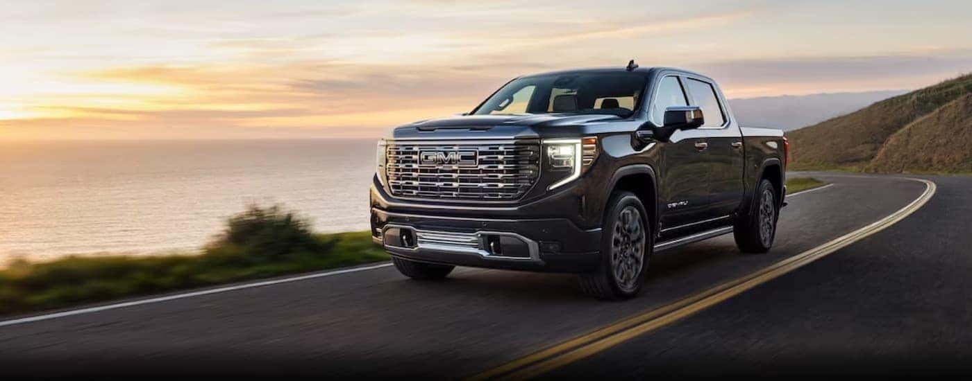 A gray 2024 GMC Sierra 1500 driving near water.