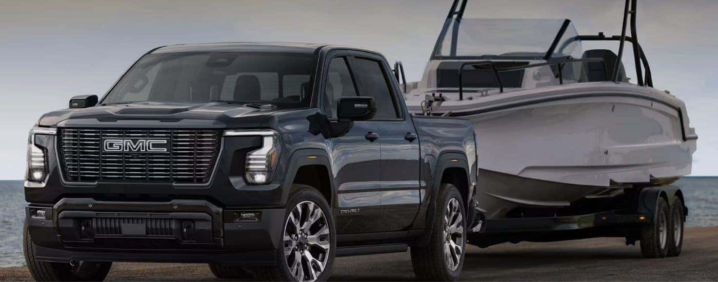 A black 2027 GMC Sierra 1500 towing a boat.