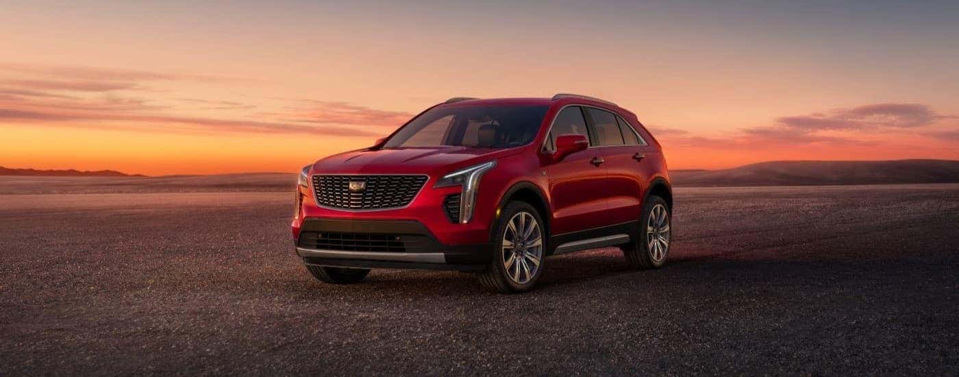 A red 2023 Cadillac XT4 is shown parked at sunset.