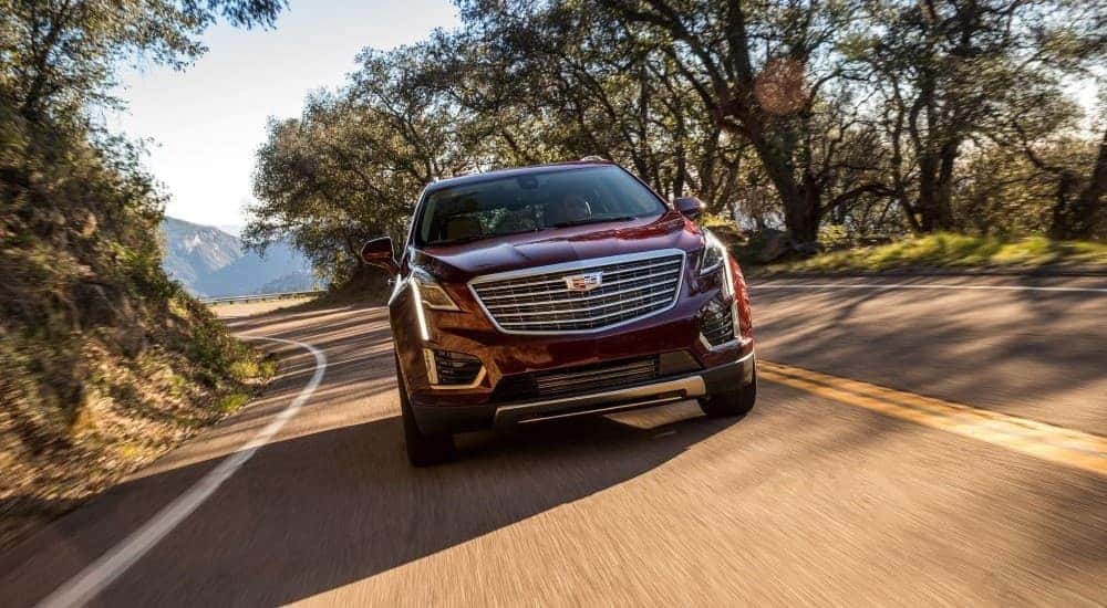 A red 2019 Cadillac XT5 is shown driving on an open road after leaving Cadillac Dealer in Atlanta GA.