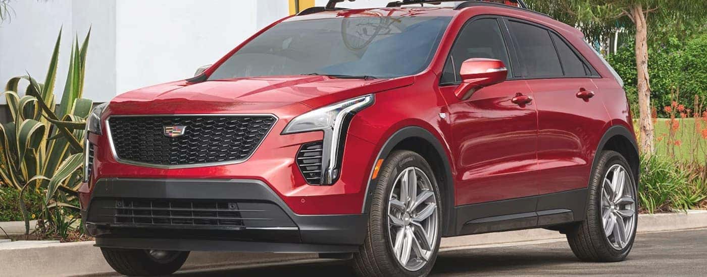 A red 2023 Cadillac XT4 is parked on a suburban street