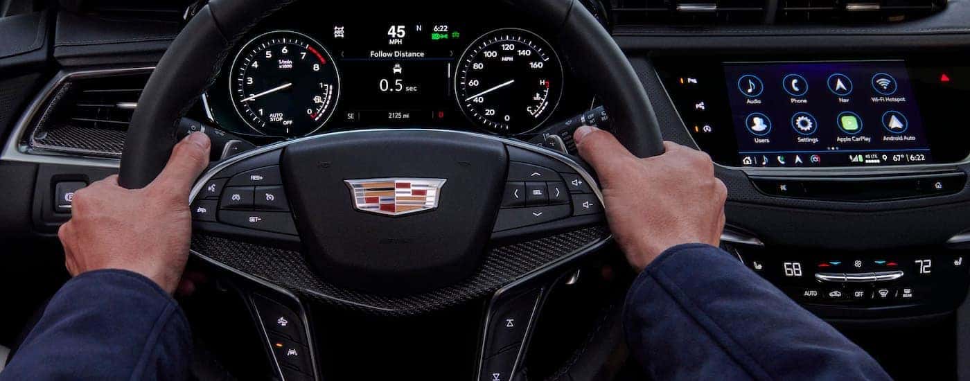 The black dash of a 2023 Cadillac XT5 is shown from the driver's seat.