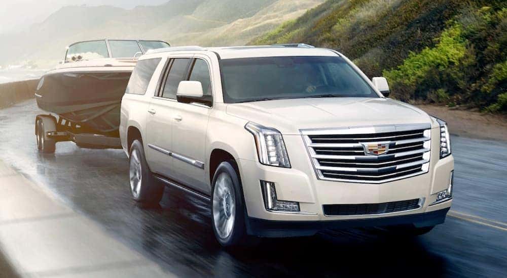 A white 2020 Cadillac Escalade is shown towing a boat.