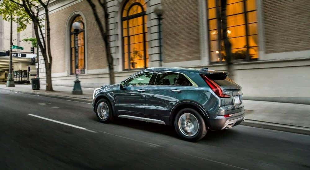 A blue 2019 Cadillac XT4 is shown on a city street.
