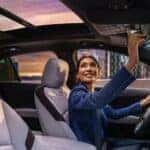 A person is shown opening the moonroof in a 2024 Cadillac XT4.