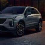 A silver 2024 Cadillac XT4 for sale is shown parked at night.