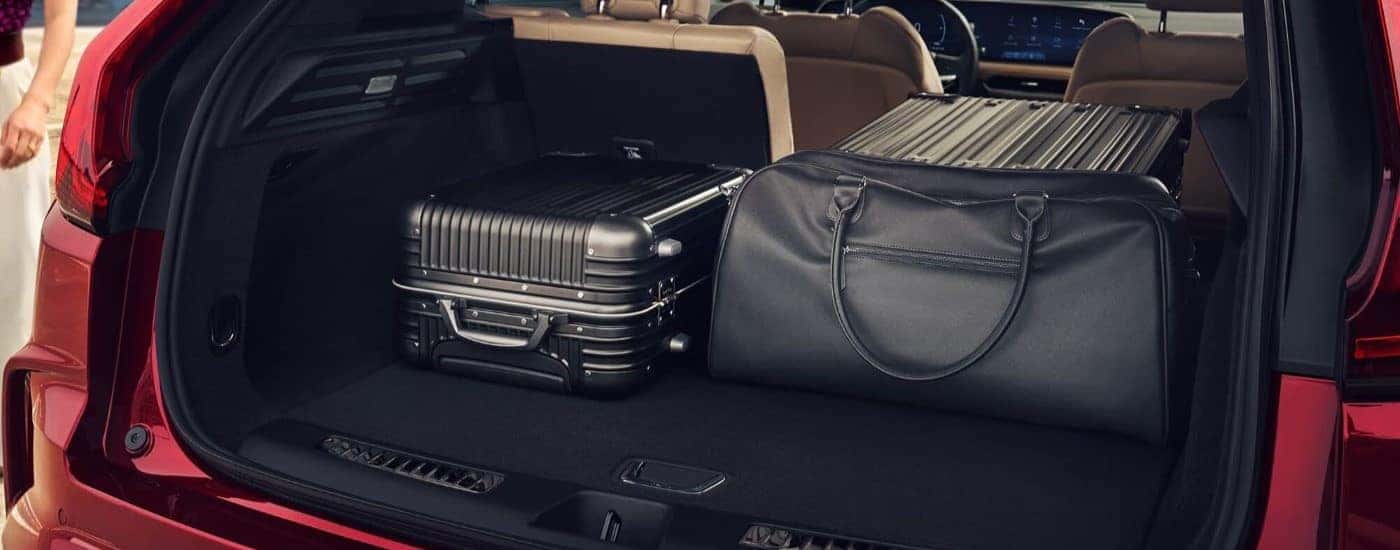 Luggage is shown in the trunk of a red 2024 Cadillac XT4.