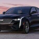 A black 2024 Cadillac CT4 is shown parked off-road after visiting a Cadillac dealer near me.