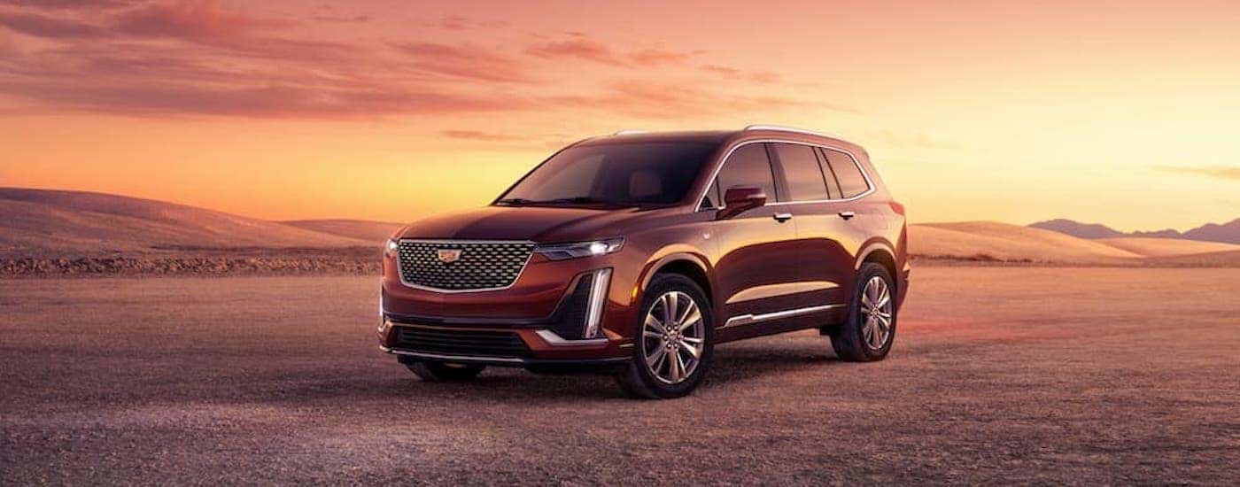 A red 2023 Cadillac XT6 is shown from the side after leaving a Buckhead Cadillac dealer.
