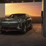 A green 2024 Cadillac LYRIQ is shown charging near a Cadillac dealer near Smyrna.