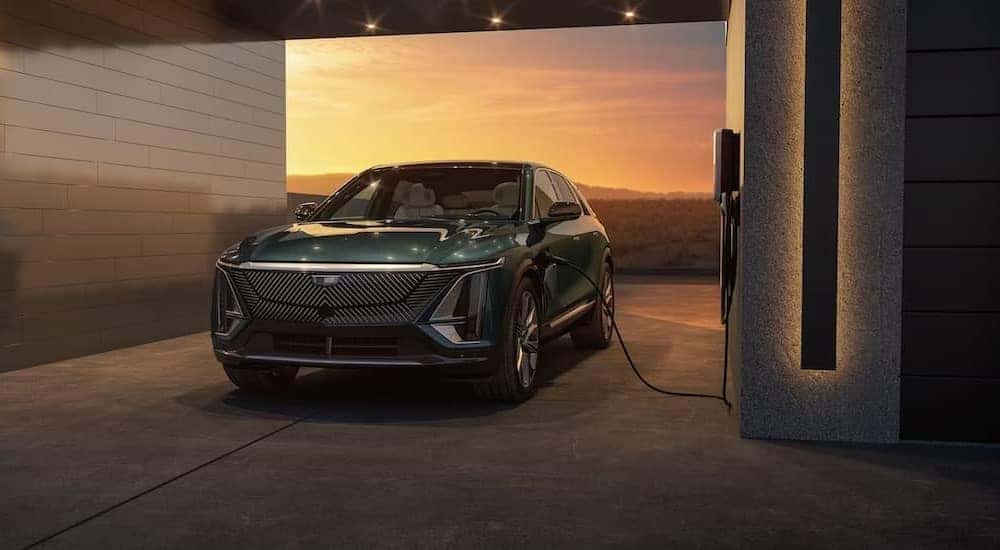 A green 2024 Cadillac LYRIQ is shown charging near a Cadillac dealer near Smyrna.