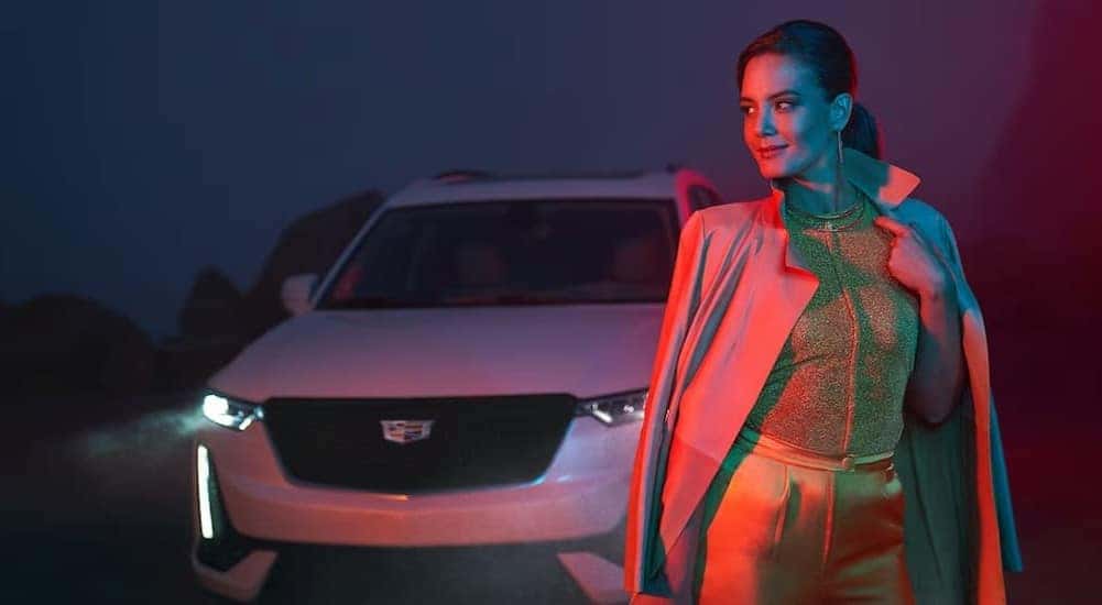 A white 2024 Cadillac XT6 is shown parked near a person.