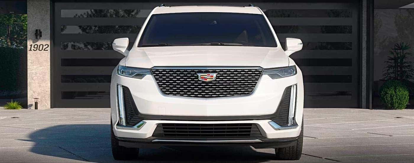 A white 2024 Cadillac XT6 is shown parked in a driveway.