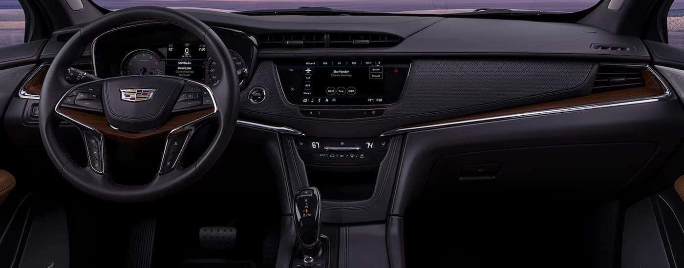 The black interior of a 2024 Cadillac XT6 is shown from the front seat.