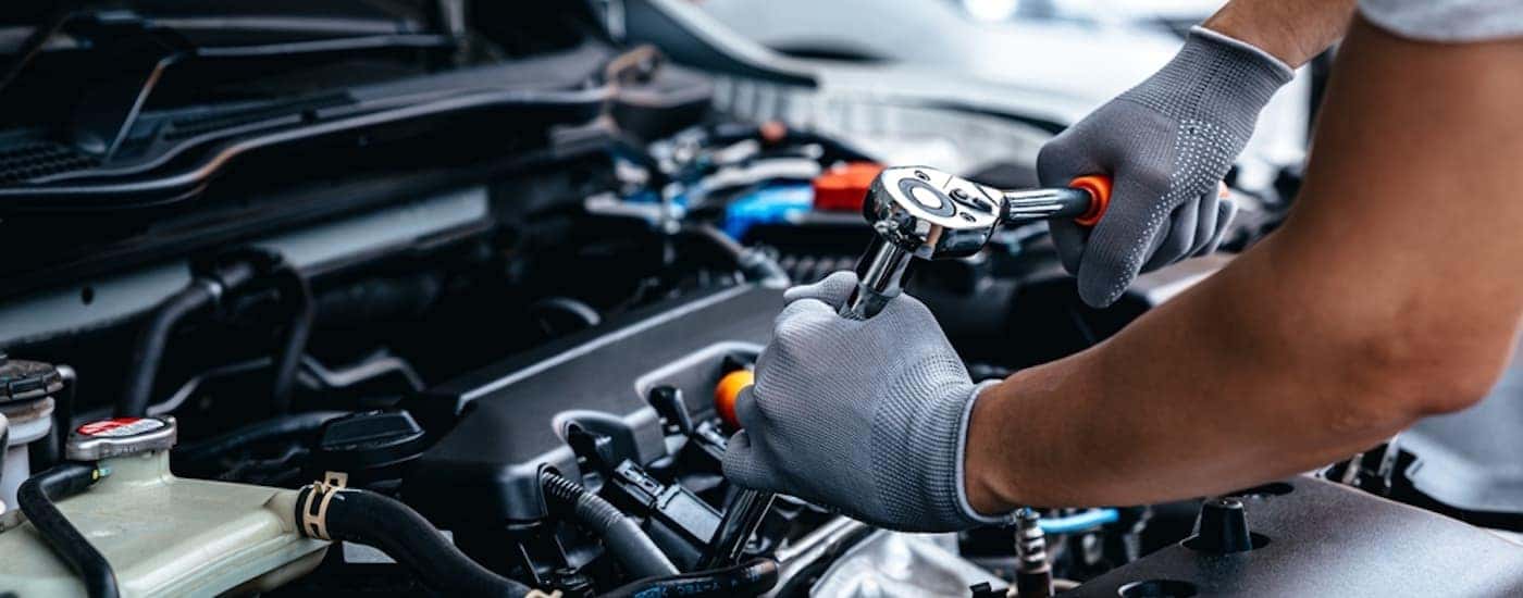 A mechanic is shown working on an engine.