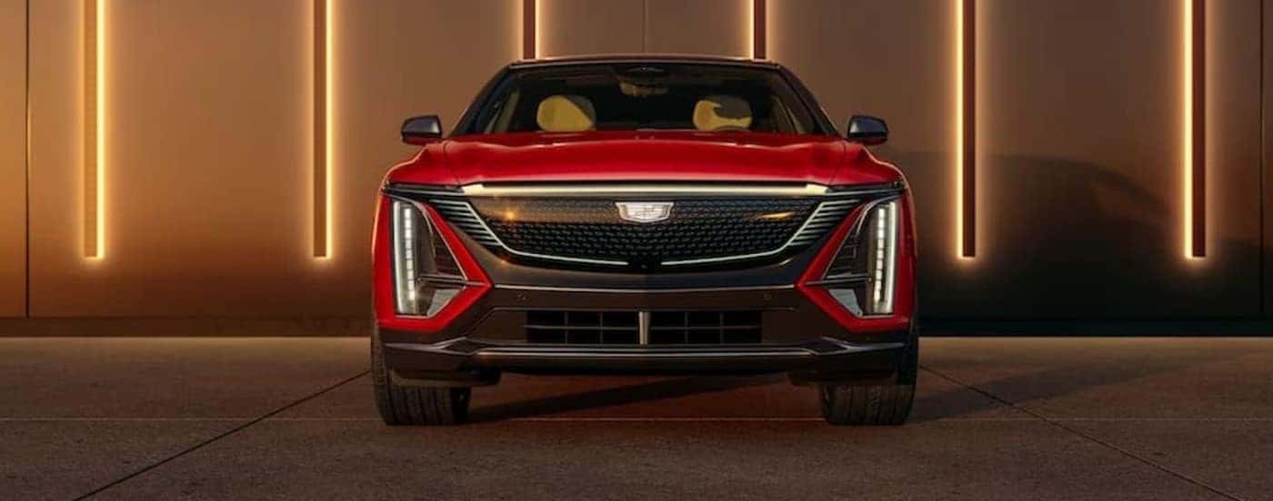 A red 2024 Cadillac LYRIQ is shown parked near lights.