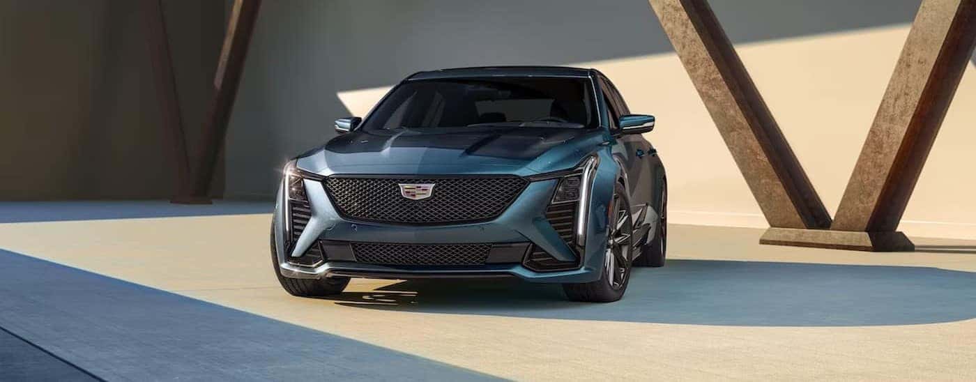 A blue 2025 Cadillac CT5 is shown parked near support beams.