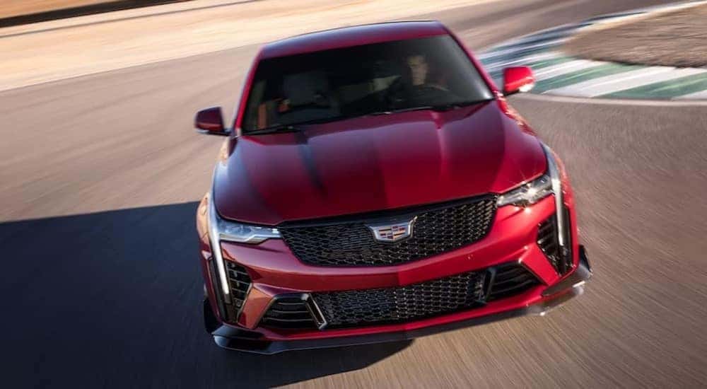 A red 2023 Cadillac CT4-V Blackwing is shown driving from a front angle.