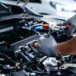 A mechanic is shown performing repairs on a car engine at a Cadillac service center near Doraville.