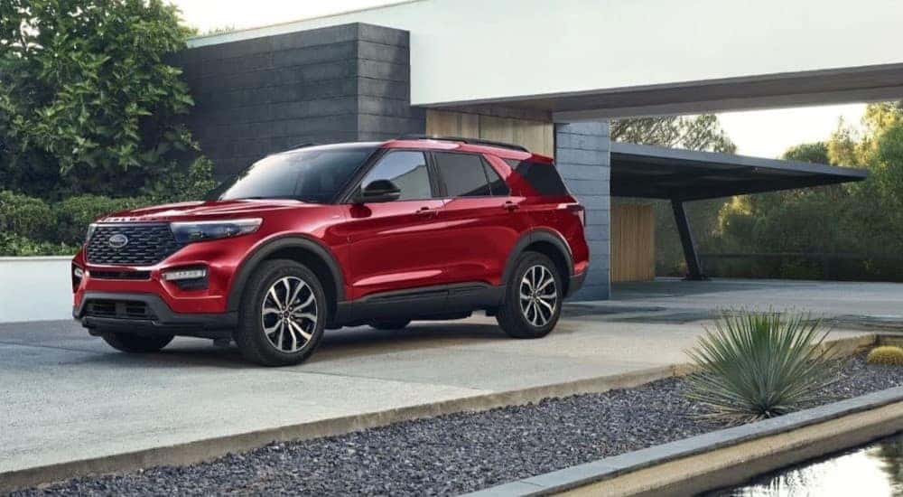 A red 2024 Ford Explorer ST-Line is shown parked near a house.