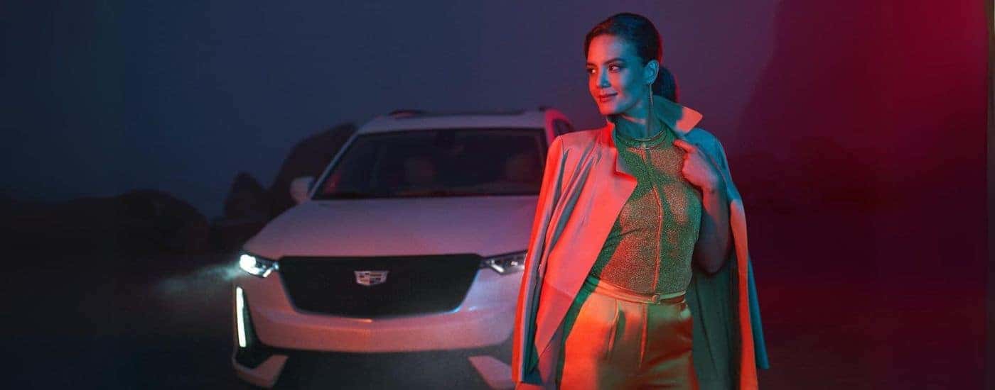 A person is shown walking past a white 2024 Cadillac XT6.