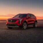 A red 2024 Cadillac XT4 parked off-road in a desert.