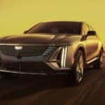 A silver 2024 Cadillac LYRIQ Luxury driving in a golden haze.
