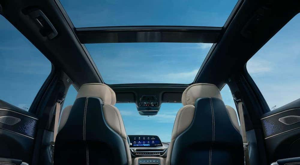 The black and white interior is shown from the back seat of a 2024 Cadillac LYRIQ.