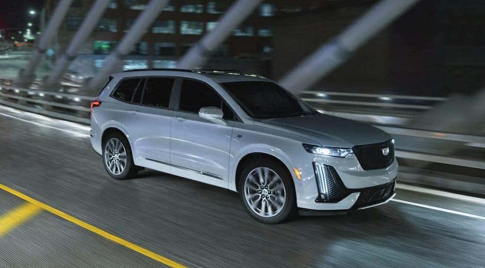 A grey 2024 Cadillac XT6 driving across a bridge.