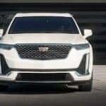 A front view of a white 2024 Cadillac XT6 parked on a driveway.