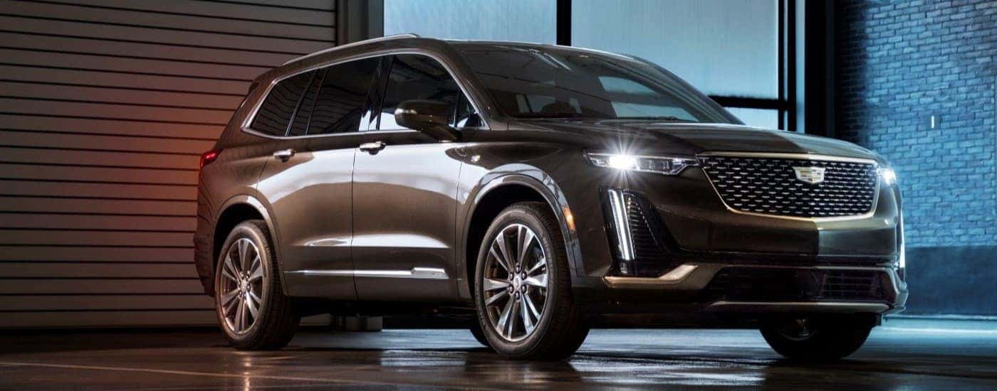 A gray 2020 Cadillac XT6 is shown parked on a rainy night.