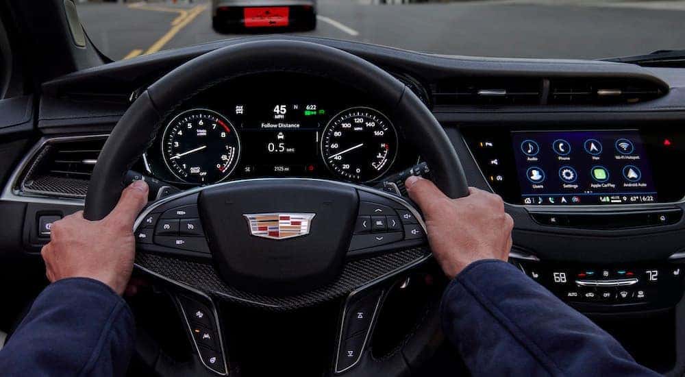 The black dash of a 2023 Cadillac XT5 is shown from the driver's seat.