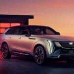 A silver 2025 Cadillac Escalade IQ is shown parked on a driveway.