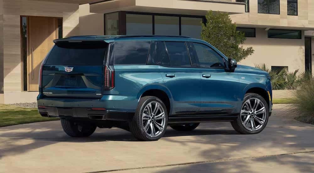 Rear view of a green 2025 Cadillac Escalade angled right.